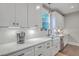 Bright kitchen boasts white cabinets, quartz countertops, and a farmhouse sink at 1935 Chestnut Oak Ln, Charleston, SC 29414