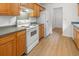 Kitchen with wood cabinets, white appliances, and laminate flooring at 238 Trickle Dr, Summerville, SC 29483