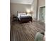 Main bedroom with hardwood floors, a wooden bed frame, and a seating area at 9049 Delancey Cir, North Charleston, SC 29406