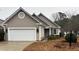 Beige house with white garage door, landscaping, and a welcoming entrance at 9049 Delancey Cir, North Charleston, SC 29406