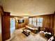 Cozy living room featuring wood paneling, a comfortable sofa, and large windows at 208 Howard St, Varnville, SC 29944
