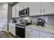 Modern kitchen with white cabinets, stainless steel appliances and gray backsplash at 435 Eva St, Moncks Corner, SC 29461