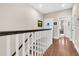 Hallway with hardwood floors, white railing, and access to bathroom at 2111 Tides End Rd, Charleston, SC 29412