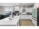 White kitchen with large island, stainless steel appliances and wood floors at 655 Black Pine Rd, Moncks Corner, SC 29461
