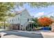 Renovated light green house with a side yard and stairs leading to a porch at 132 Spring St, Charleston, SC 29403