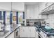 Modern white kitchen with granite countertops and stainless steel appliances at 132 Spring St, Charleston, SC 29403