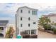 Three-story beach house, white exterior, ocean view at 1579 E Ashley Ave, Folly Beach, SC 29439