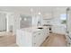 White kitchen with marble countertops and island, white cabinets, and stainless steel appliances at 1579 E Ashley Ave, Folly Beach, SC 29439