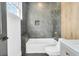 Stylish bathroom with gray tile, a white bathtub, and gold accents at 194 Nassau St, Charleston, SC 29403