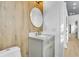 Small bathroom with a gray vanity, round mirror, and gold fixtures at 194 Nassau St, Charleston, SC 29403