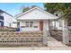 Charming white cottage with a coral door, concrete walkway, and a decorative block wall at 31 Allway St, Charleston, SC 29403