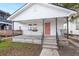 Newly renovated white cottage featuring a coral door and a welcoming front porch at 31 Allway St, Charleston, SC 29403