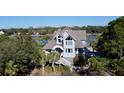 Waterfront home boasts a charming exterior and lush landscaping at 268 Little Oak Island Dr, Folly Beach, SC 29439