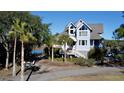 Light blue home with white trim, large windows, and palm trees at 268 Little Oak Island Dr, Folly Beach, SC 29439