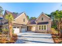 Side view of a two-story brick home featuring a porte-cochère and a two-car garage at 3820 Gnarled Oaks Ln, Johns Island, SC 29455