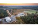 Aerial view of a farmhouse, large barn, and surrounding fields at 6500 Parkers Ferry Rd, Adams Run, SC 29426
