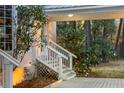 Side entrance with white wooden stairs and railing leading to a deck at 8340 Crooked Creek Ln, Edisto Island, SC 29438