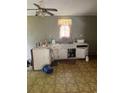 Outdated kitchen with white cabinets, linoleum floor, and a double sink at 195 Utsey Hill Rd, Saint George, SC 29477