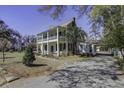 Two story home with a wrap around porch, driveway, and landscaping at 1003 Wichman St, Walterboro, SC 29488