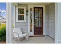 Front porch with rocking chair and dark wooden front door at 8749 Revival Round, North Charleston, SC 29420