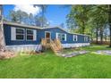 Blue mobile home with white trim, wooden deck and landscaped yard at 227 Koger Dr, Summerville, SC 29483