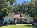Cute yellow house with blue shutters and a well-maintained lawn at 106 Teddy Ct, Summerville, SC 29485