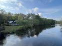 Scenic view of a house near a tranquil river under a partly cloudy sky at 138 Waddell Ln, Ridgeville, SC 29472
