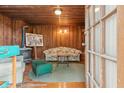 Living room with wood paneling, wood floors, and vintage furniture near door at 712 W Ashley Ave, Folly Beach, SC 29439