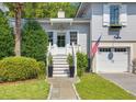 Charming front porch with white door and steps, flanked by lush greenery at 1220 Middle St, Sullivans Island, SC 29482