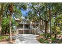 Two-story home with a large driveway and tropical landscaping at 3067 Marshgate Dr, Seabrook Island, SC 29455