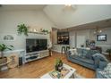 Open living space featuring a large TV, hardwood floors, and kitchen views at 1984 Folly Rd # B304, Charleston, SC 29412
