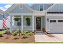 Charming front porch with white columns, hanging plants, and American flag at 2033 Kings River Trail, Hollywood, SC 29449