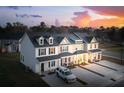 Aerial view of three townhouses with a SUV parked in the driveway at sunset at 476 Green Fern Dr, Summerville, SC 29483