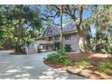 A gorgeous house nestled among trees, with a long driveway and lush landscaping at 202 Needlerush Rd, Kiawah Island, SC 29455