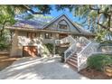 A charming house with a grey exterior, white stairs, and a spacious driveway at 202 Needlerush Rd, Kiawah Island, SC 29455
