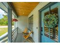 Inviting front porch with blue door, wood ceiling and comfy seating at 3820 Gardenhill Rd, Mount Pleasant, SC 29429