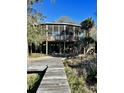 Elevated home with a large screened porch and dock access at 3001 Buccaneer Rd, Isle of Palms, SC 29451