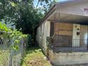 Side view of neglected house with boarded windows and overgrown vines at 17 Reid St, Charleston, SC 29403