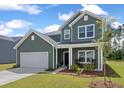 Two story green house with rocking chairs on the porch at 4413 Palm Shadow Dr, Summerville, SC 29485