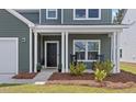 Front porch of a two story home with rocking chairs at 4413 Palm Shadow Dr, Summerville, SC 29485