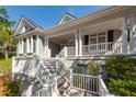 Elevated home with white columns and a welcoming front porch at 3064 Marshgate Dr, Seabrook Island, SC 29455