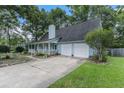Light blue house with a white porch, two-car garage, and landscaped yard at 137 Fox Chase Dr, Goose Creek, SC 29445