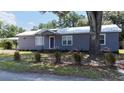 Charming bungalow with a metal roof, purple exterior, and well-manicured landscaping at 110 Groves St, Walterboro, SC 29488