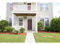 House exterior featuring a front porch, American flag, and well-maintained landscaping at 131 Tin Can Aly, Summerville, SC 29483