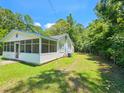 View of the house's side, highlighting the screened porch and landscaping at 212 Hickory St, Walterboro, SC 29488