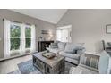 Bright living room with a comfortable sofa, coffee table and large windows at 202 Mariners Cay Dr, Folly Beach, SC 29439