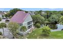Two-story house with a metal roof and screened porch, near a pond at 202 Mariners Cay Dr, Folly Beach, SC 29439