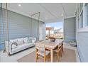 Relaxing covered patio with a swing, dining table, and comfortable seating at 450 Ripple Park Dr, Summerville, SC 29486