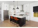 Modern kitchen with white cabinets, large island, and stainless steel appliances at 411 Swaying Pine Lane, Summerville, SC 29486
