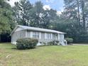 Gray sided ranch home with metal roof, surrounded by trees at 313 Pine Needle Rd, Walterboro, SC 29488
